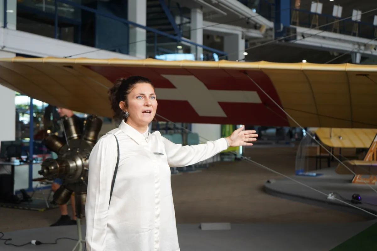 Eine Frau zeigt auf ein Flugzeug.