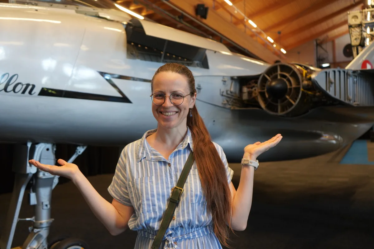 Eine Frau vor einem Kampfjet.