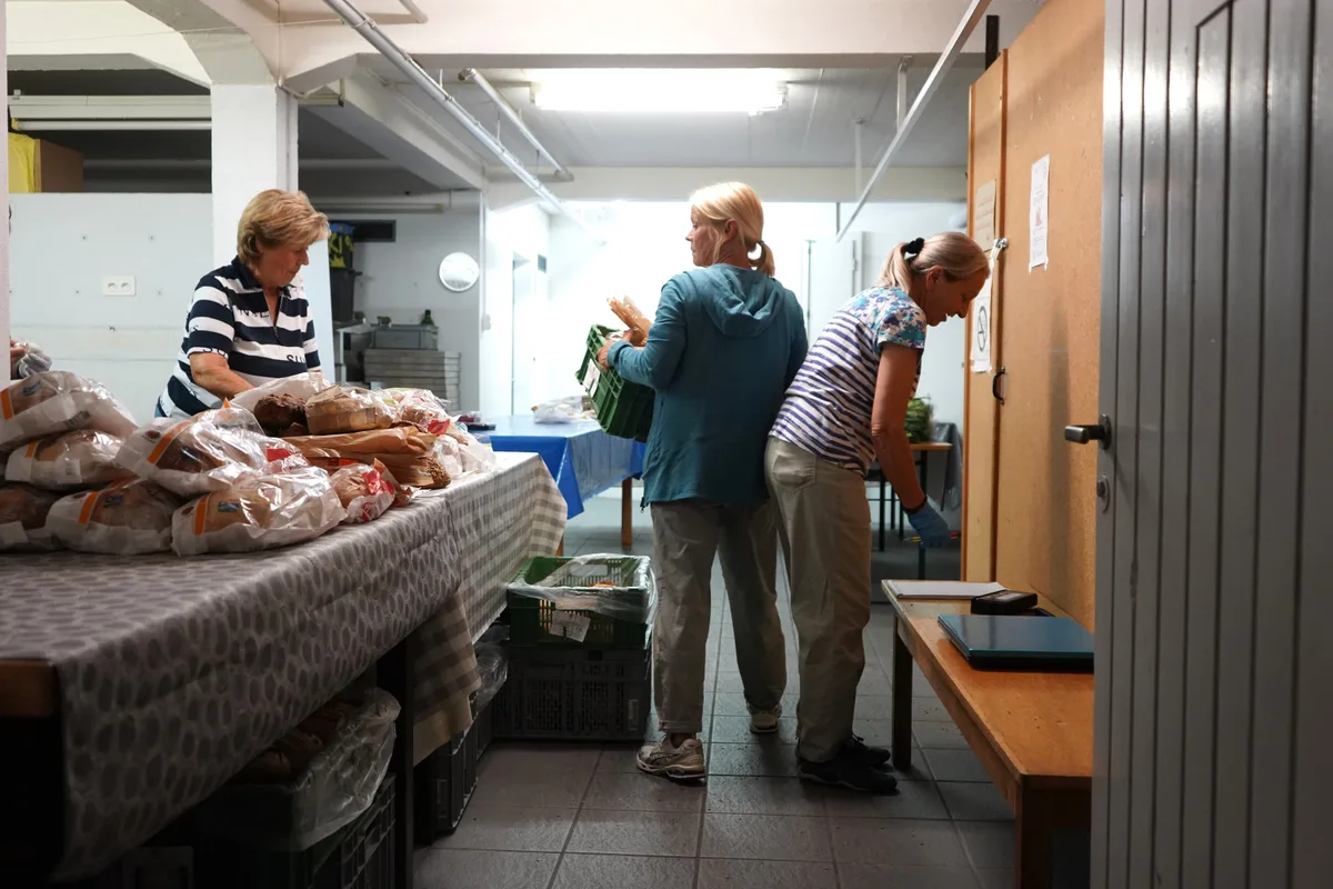 Die Frauen des Vereins arbeiten emsig daran, die erhaltenen Esswaren zu sortieren und für die Bezüger bereitzustellen. Drei Frauen in einem Keller.