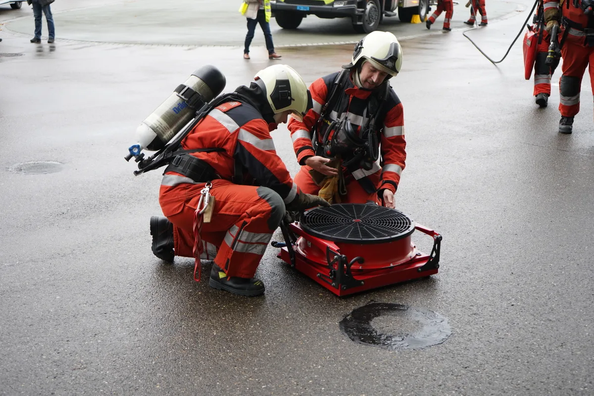 Feuerwehrleute bereiten einen Ventilator für die Entlüftung des Stadthauses Dübendorf vor.