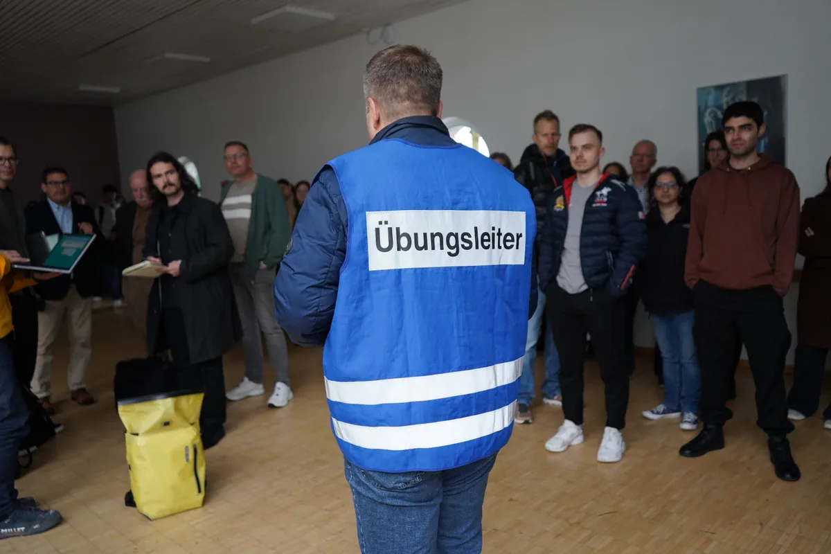 Der Übungsleiter Michel Elmer steht vor einer Gruppe städtischer Angestellter. 