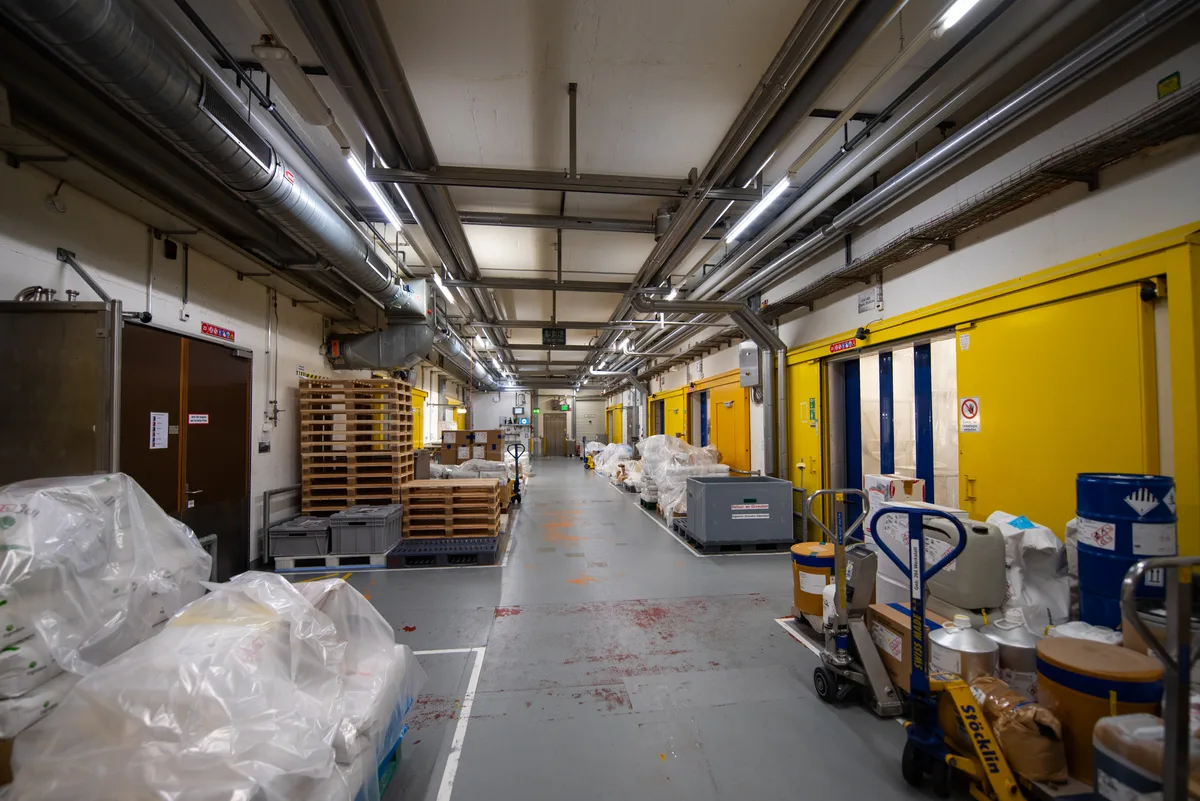 Von diesem Gang gelangt man in die Räume mit den sieben Sprühtürmen, die Tag und Nacht laufen und Aromen produzieren. Blick auf einen Gang in einer Fabrik.