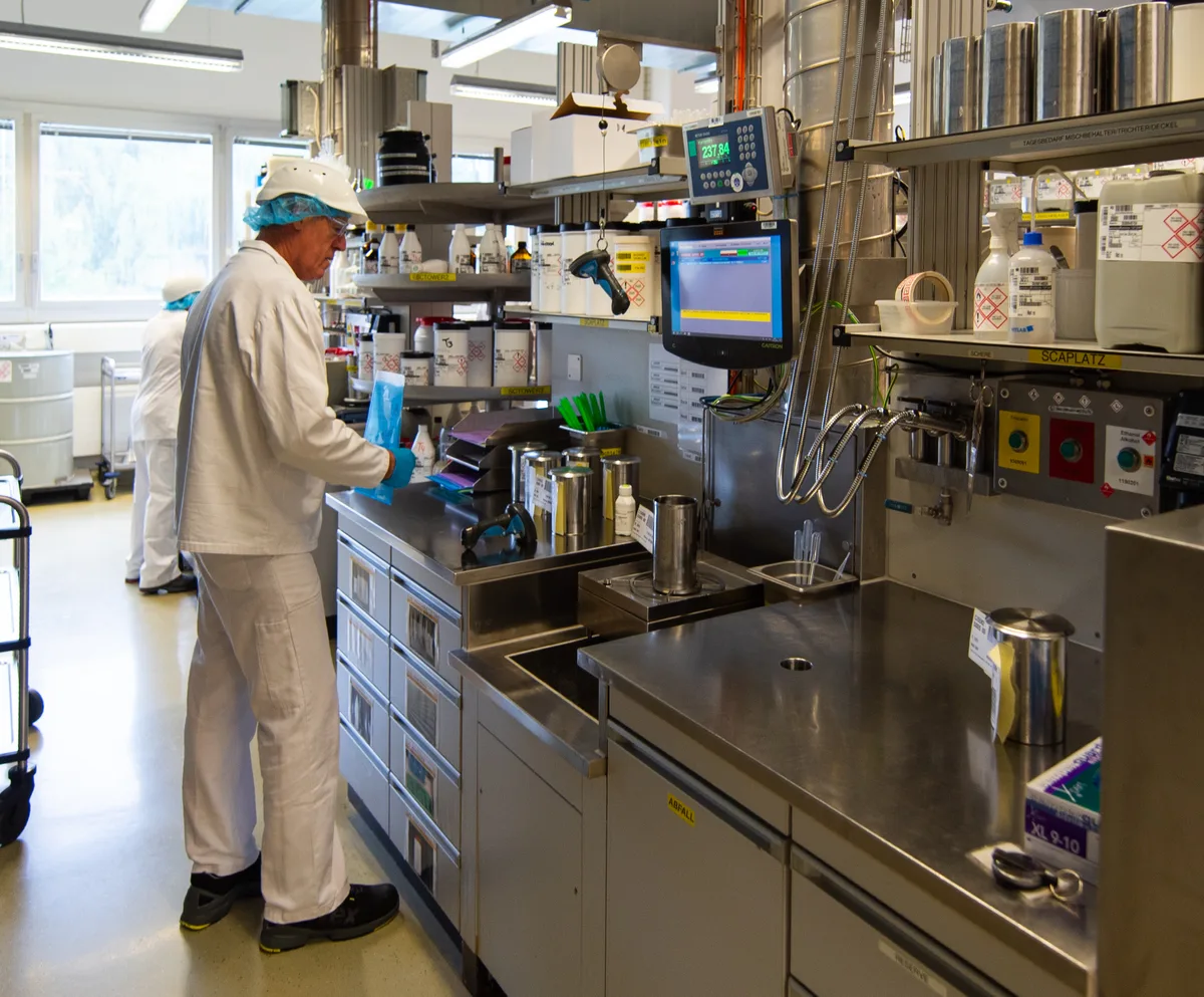 Im Labor werden die Produkte getestet, sensorisch und chemisch. Sie müssen einen hohen Qualitätsstandard erfüllen. Ein Mann arbeitet in einem Labor.