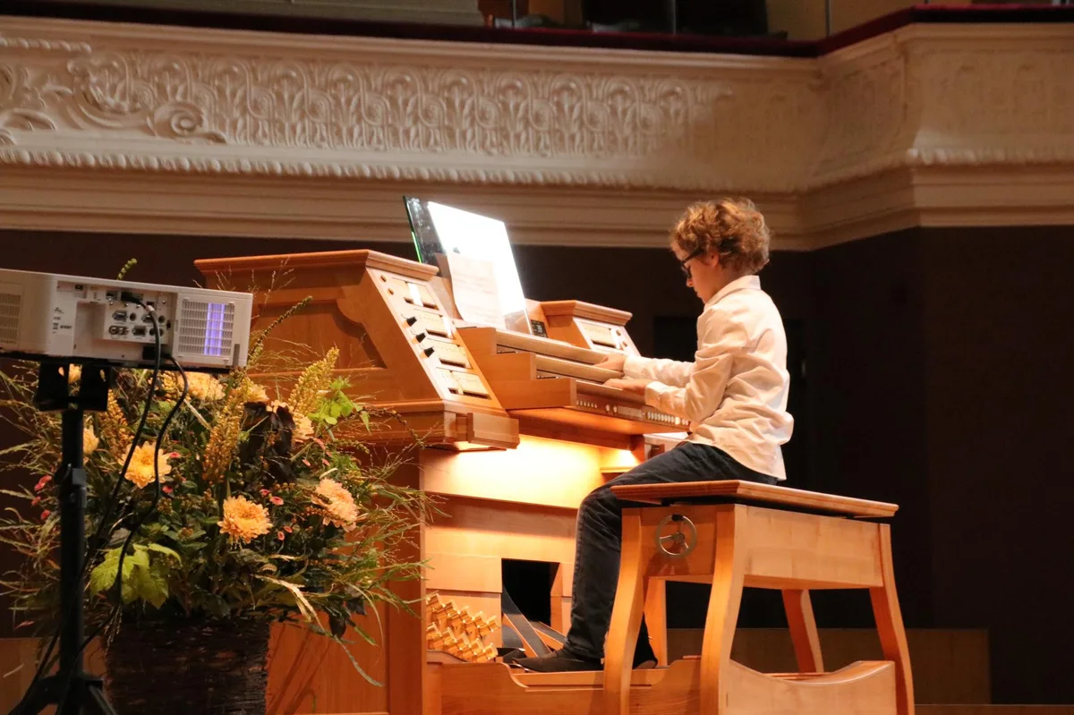 Ein Kind spielt auf der Orgel.