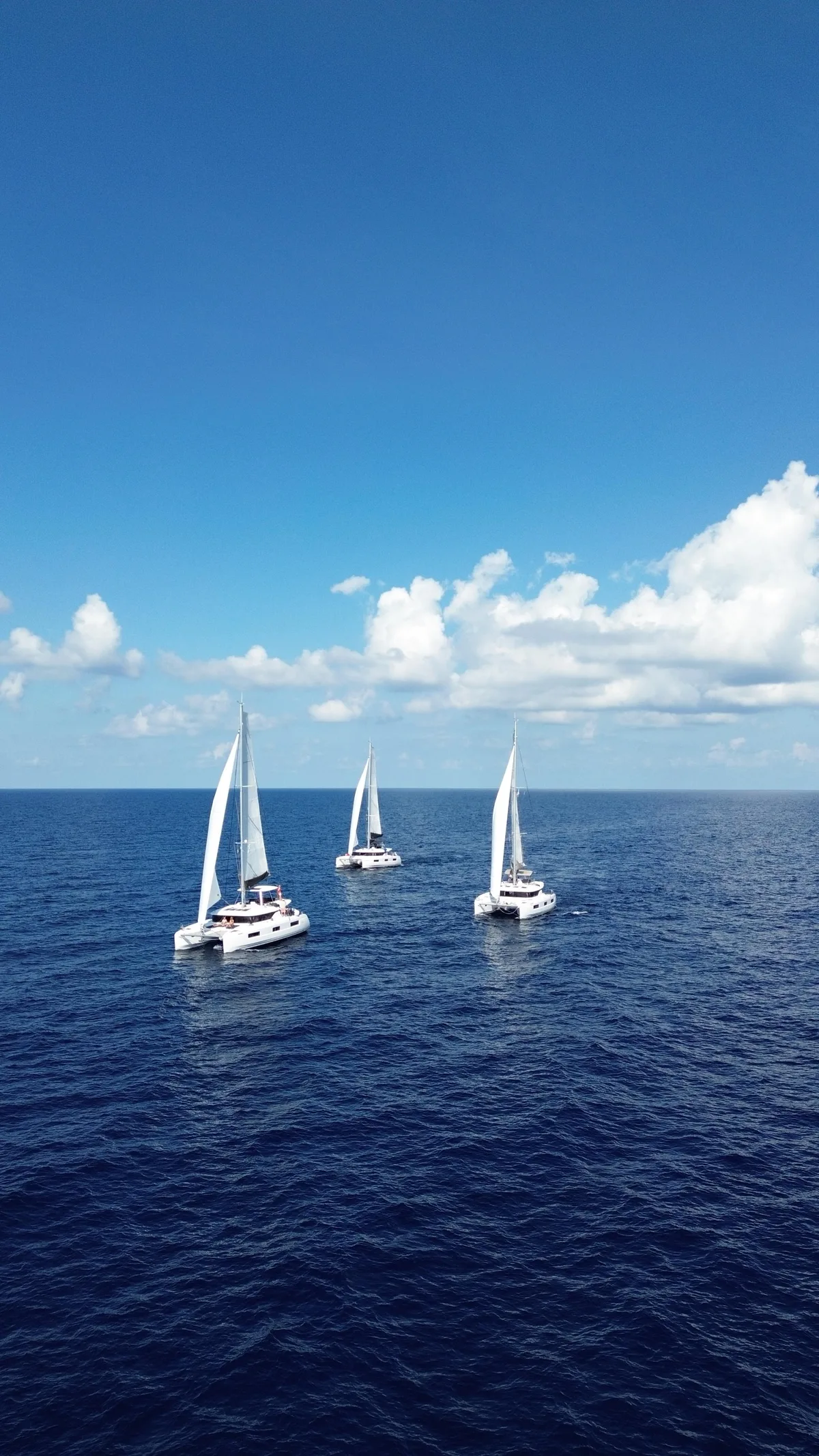 Drei der Katamarane von derselben Organisation haben zusammen die Überfahrt gewagt. Blick auf die drei Katamarane im Atlantik.
