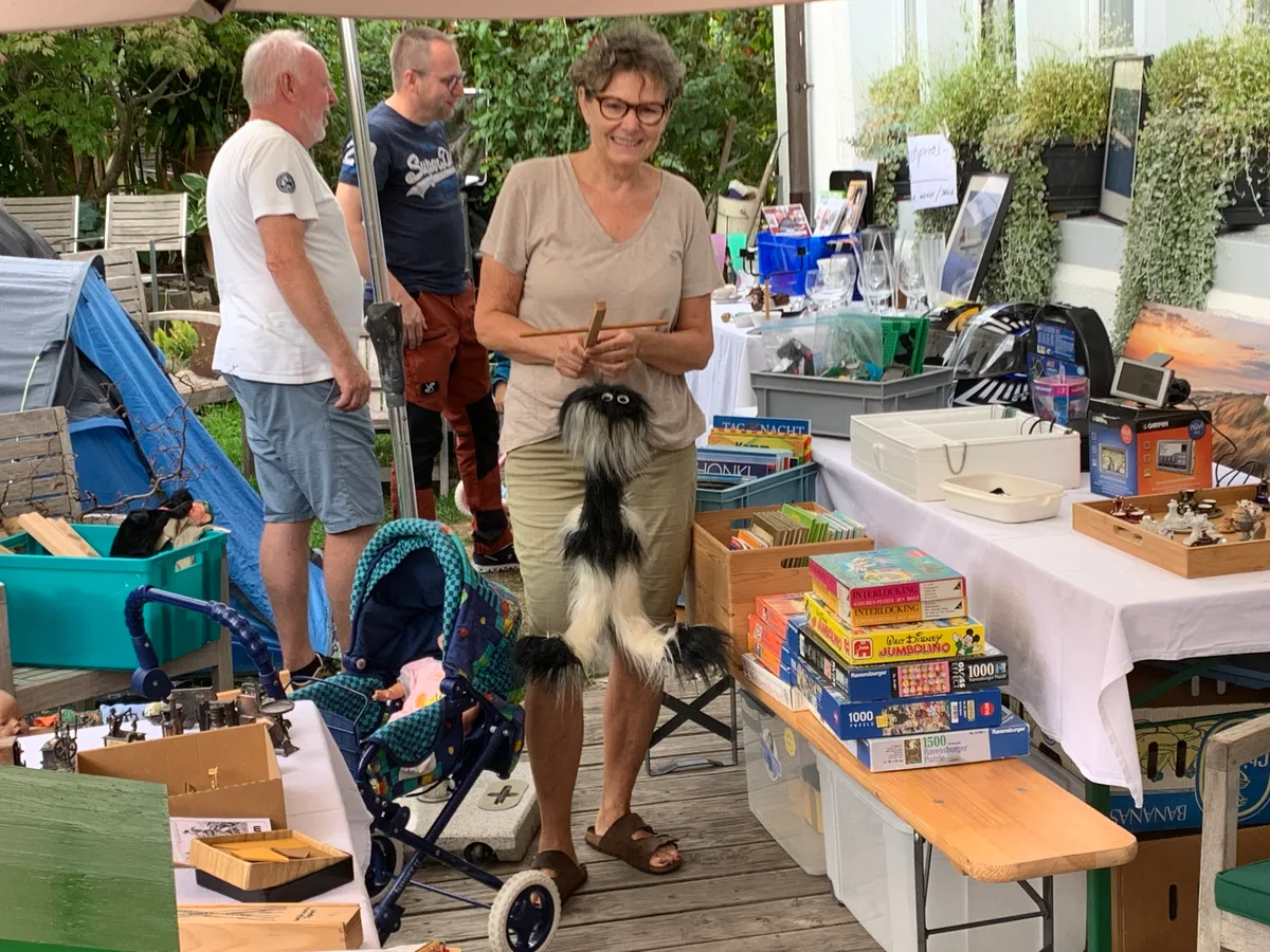 Christa Ramseier mit einer Marionette, die lange auf dem Estrich gelagert wurde. Flohmarktstände mit Flohmarktgegenständen.