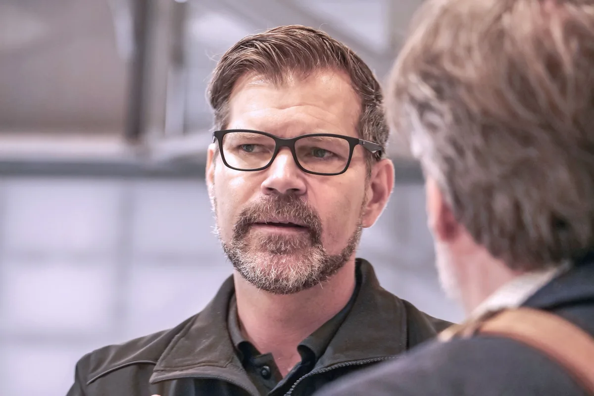 Sascha Hardegger, CEO von Dufour Aerospace in Dübendorf, im Hangar, in dem produziert wird. Er trägt Brille, einen kurzen Bart und eine schwarze Jacke.