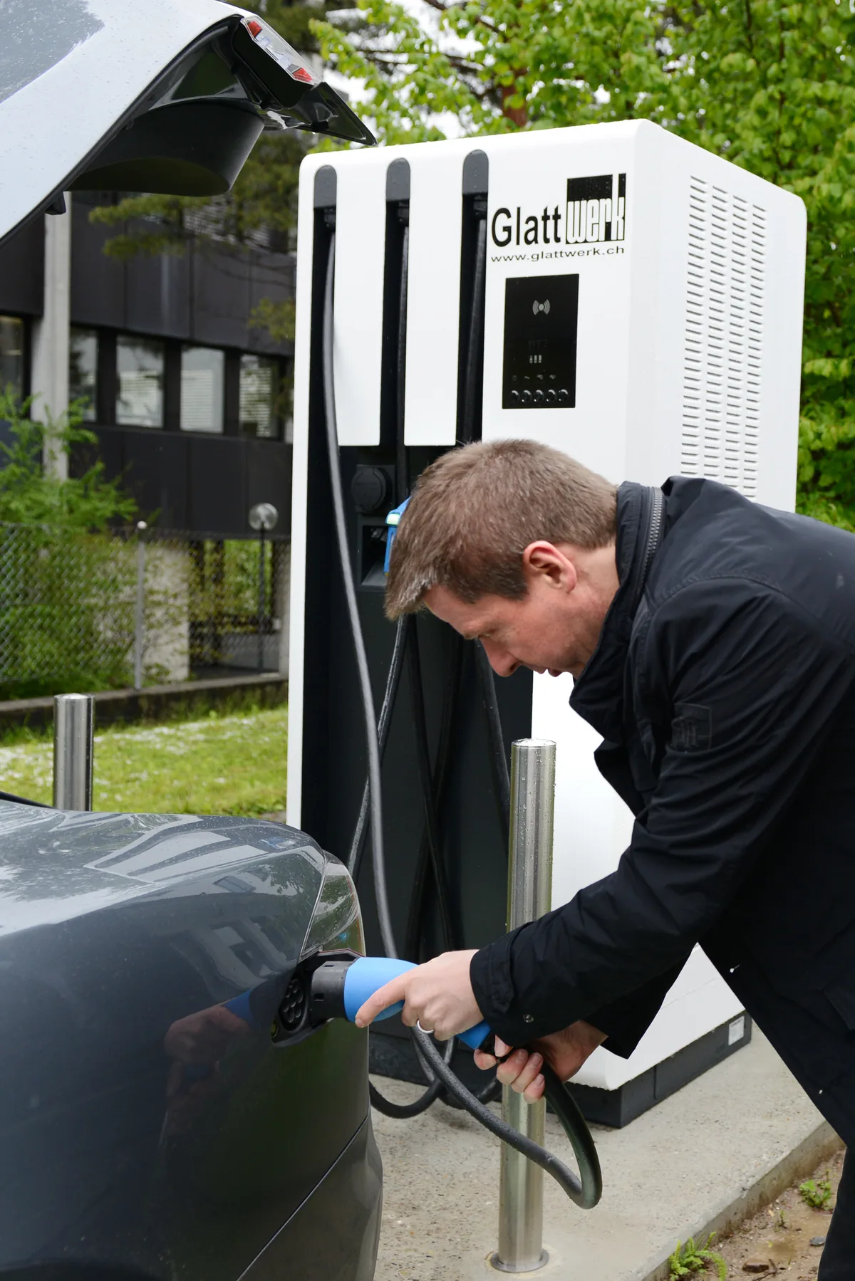 Ein Mann lädt ein E-Auto. 