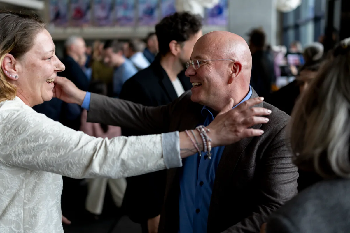 Zwei Personen begegnen sich freundschaftlich.