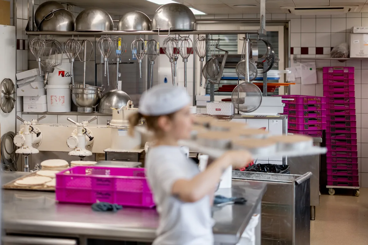 Eine Bäckereiangestellte arbeitet in einer Bäckerei.
