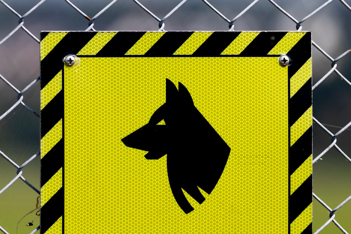Warnung vor dem Hunde: Hinweisschild beim Flugplatz Dübendorf. Gelb-schwarzes Hunde-Warnschild.