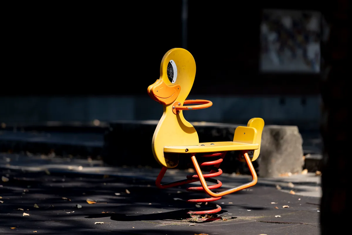 Diese Ente schaukelt auf dem Spielplatz beim Schulhaus Flugfeld in Dübendorf. Spielzeugtier zum Schaukeln auf einem Spielplatz.