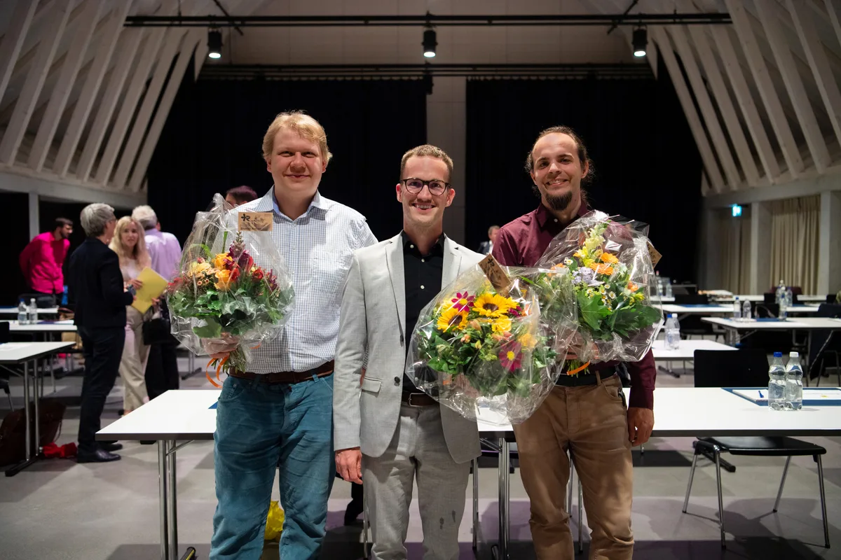 Von links: Julian Croci (Grüne), Christian Meyer (GEU/GLP) und Christian Gross (SP) freuen sich über ihre Wahl. Von links: Julian Croci (Grüne), Christian Meyer (GEU/GLP) und Christian Gross (SP) posieren mit einem Strauss.