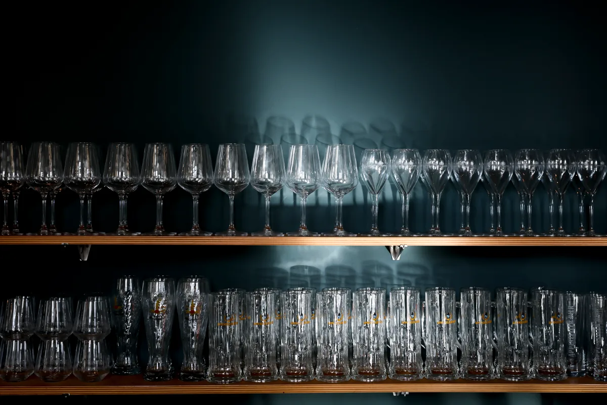 Die Gläser warten darauf, befüllt – und wieder geleert zu werden. Blick auf ein Regal mit Gläsern.