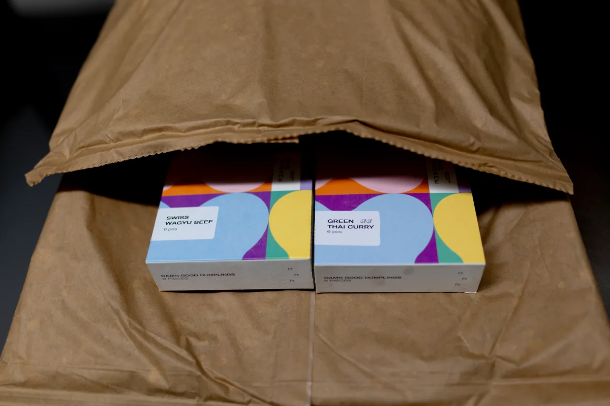Zwei Dumpling-Packungen in einem Kartonsack.