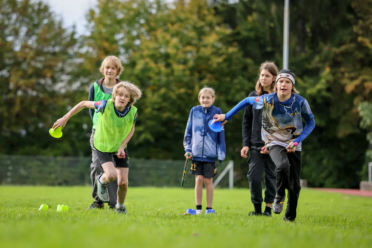 Mit Stafettenläufen trainieren die Kinder Schnelligkeit und Teamgeist. Kinder spielen Quadball.