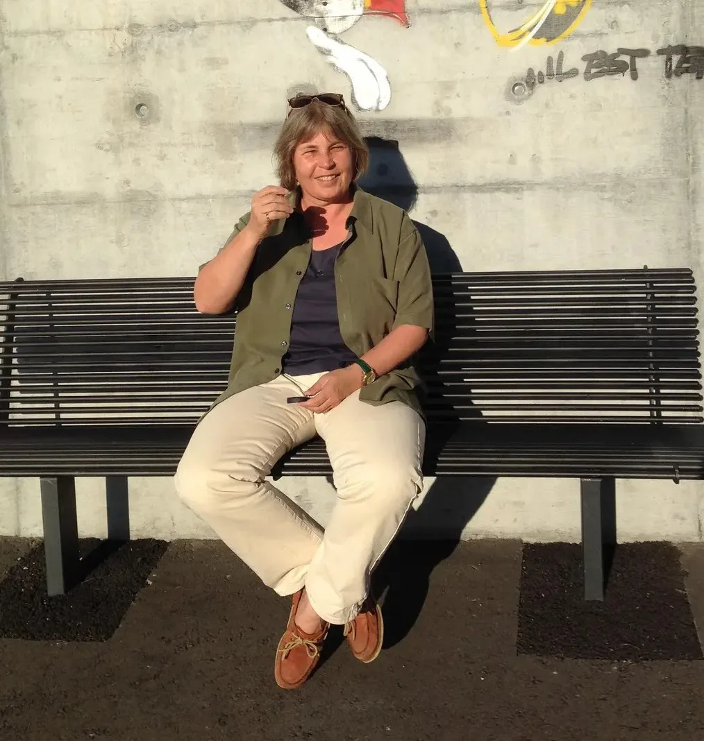 Frau sitzt auf einer Bank.