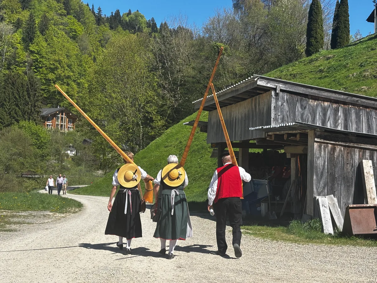 Alphornspieler mit geschultertem Instrument.