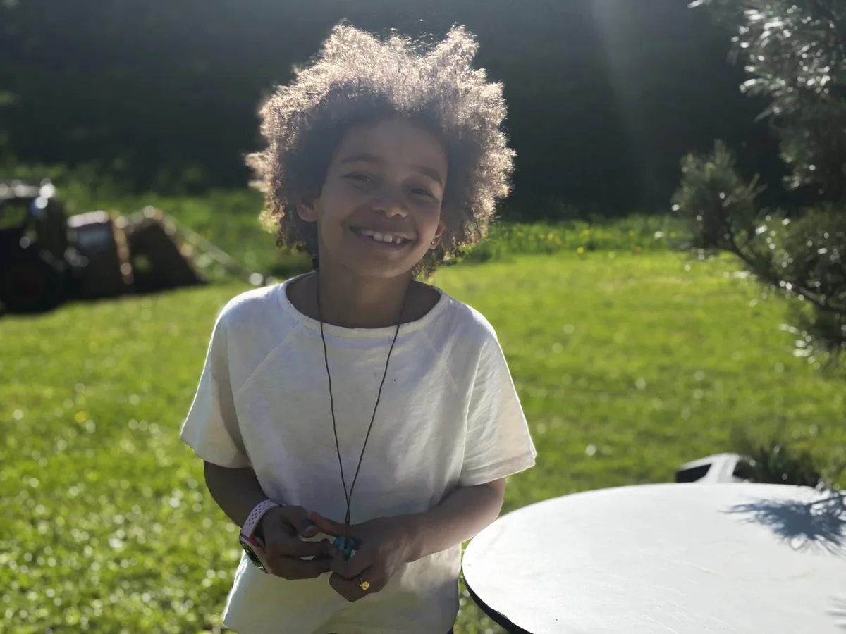 Ein Mädchen lacht in die Kamera.