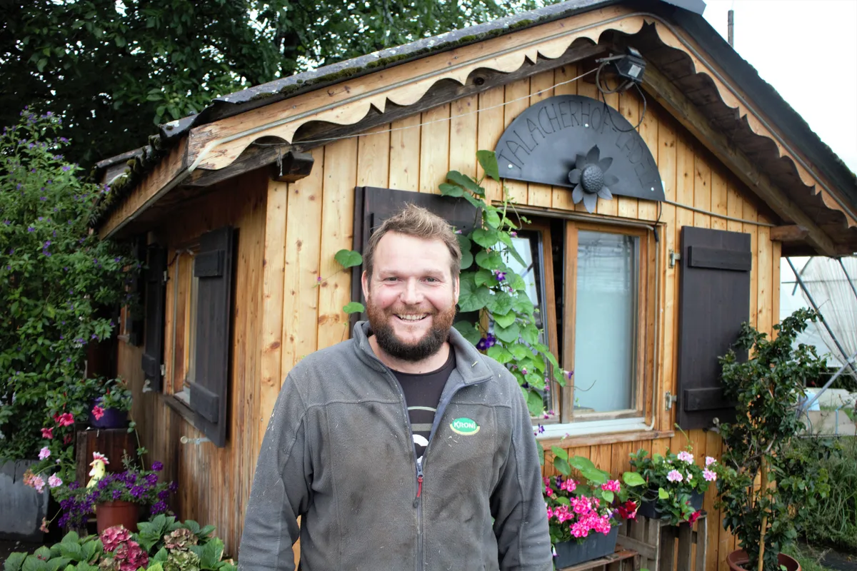 Patrick Vollenweider hatte bisher eine gute Saison. Man sieht einen Mann, der vor einem Holzhäuschen steht.