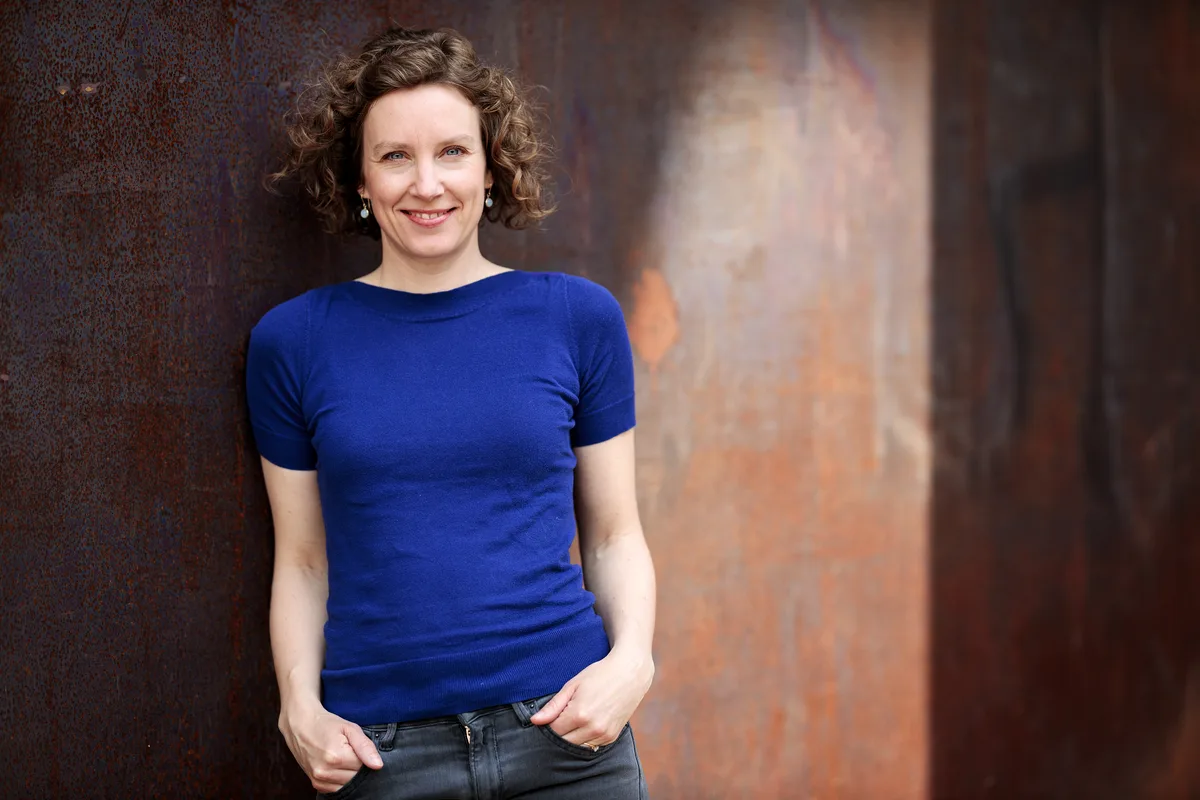 Kathrin Moeschlin ist Historikerin bei der Arbeitsgemeinschaft "Klio - Raum für Geschichte". Man sieht eine Frau in einem weissen Shirt.