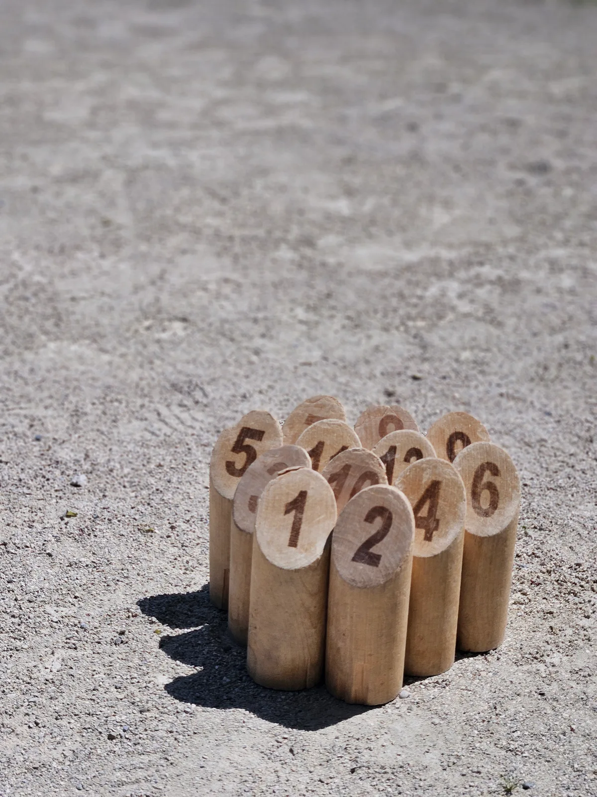 Zu Beginn des Mölkky-Spiels sind die Holzkegel nah beieinander aufgestellt. Man sieht die aufgestellten Kegel des Mölkky-Spiels.