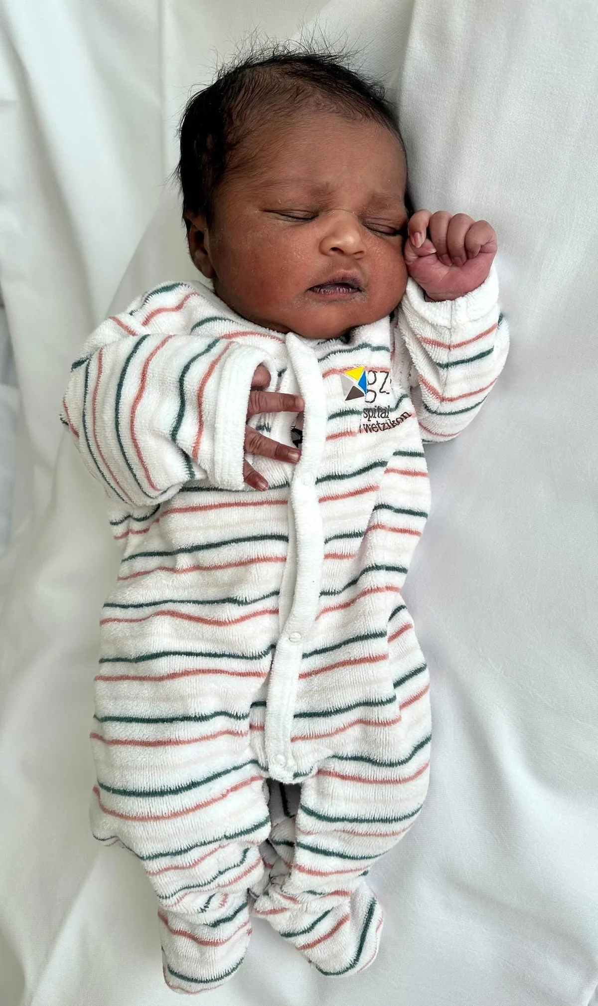Abinaya ist kurz nach halb vier geboren. Ein Baby in einem gestreiften Body.