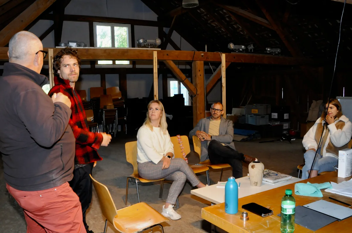 Man sieht Schauspieler und Regisseur am Proben eines Stücks.