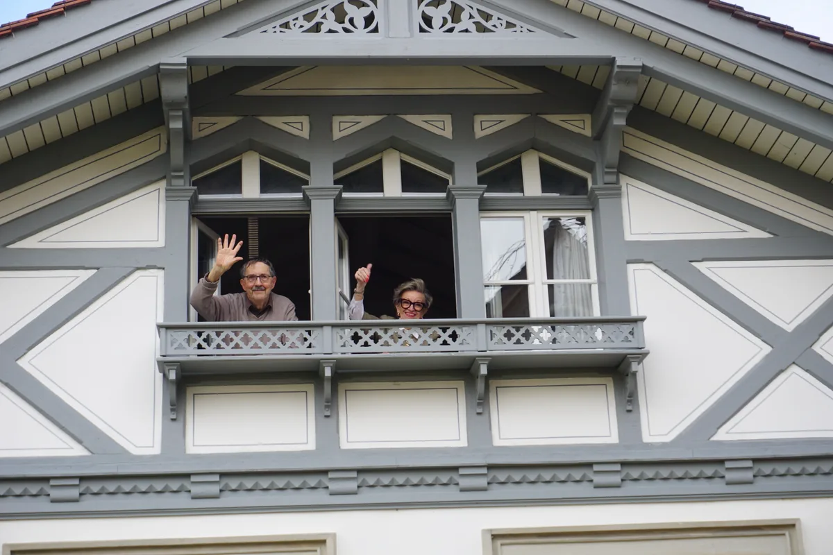 Zwei winken aus Fenster