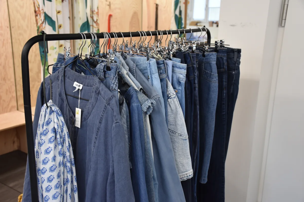 Ein Kleiderständer mit Jeansjacken und -hosen.
