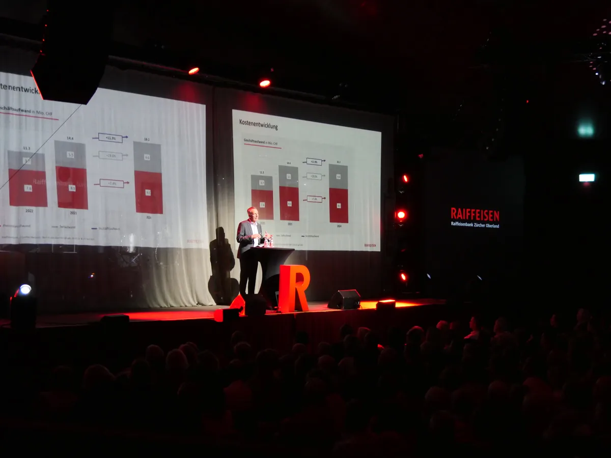 Stefan Wyss präsentierte das Jahresergebnis eines herausfordernden Geschäftsjahrs 2024. Ein Mann steht auf einer Bühne und referiert. Vor dem Rednerpult steht ein grosses, rotes R.