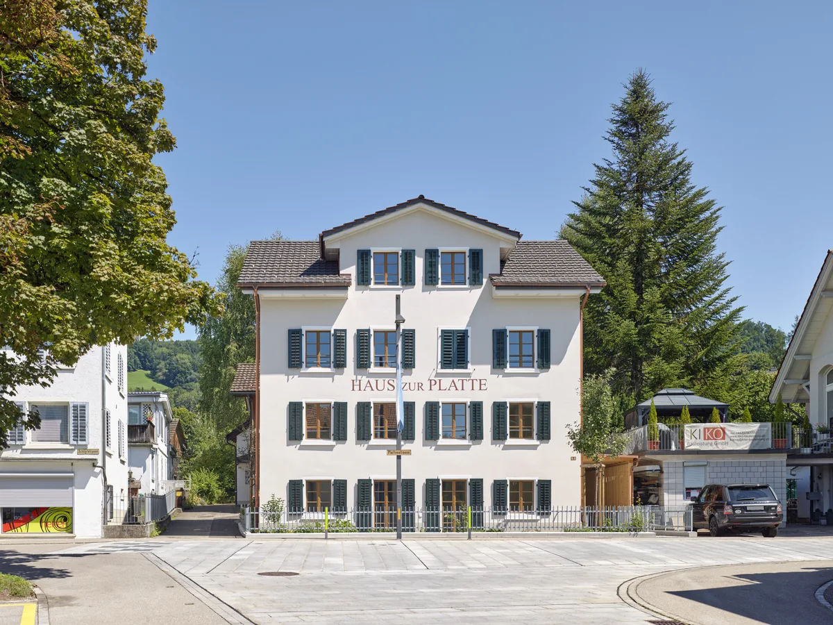 Das Haus zur Platte erstrahlt in neuem Glanz. Aussenansicht des sanierten Hauses zur Platte in Wald. Ein dreistöckiges, stattliches Haus mit Satteldach und grünen Fensterläden.