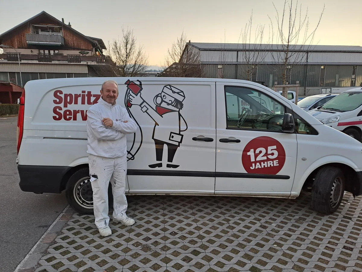 Ein Maler steht vor einem Service-Spritzbus der Schaub Maler AG.