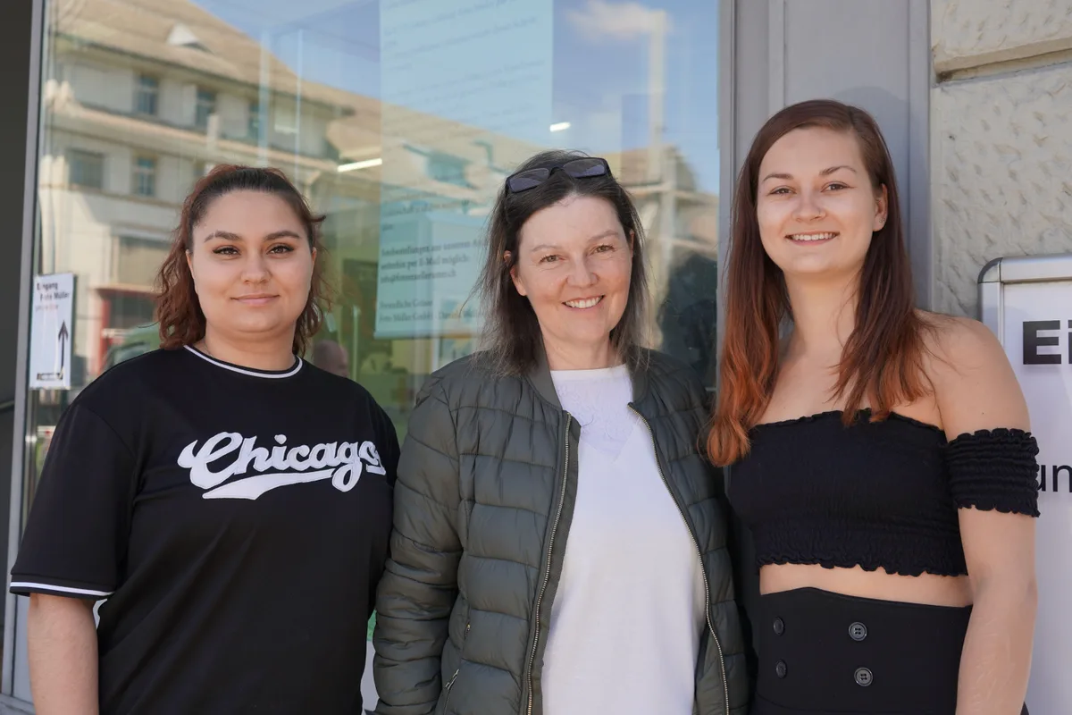 Drei Frauen posieren vor dem Schaufenster von Foto Müller für die Kamera.