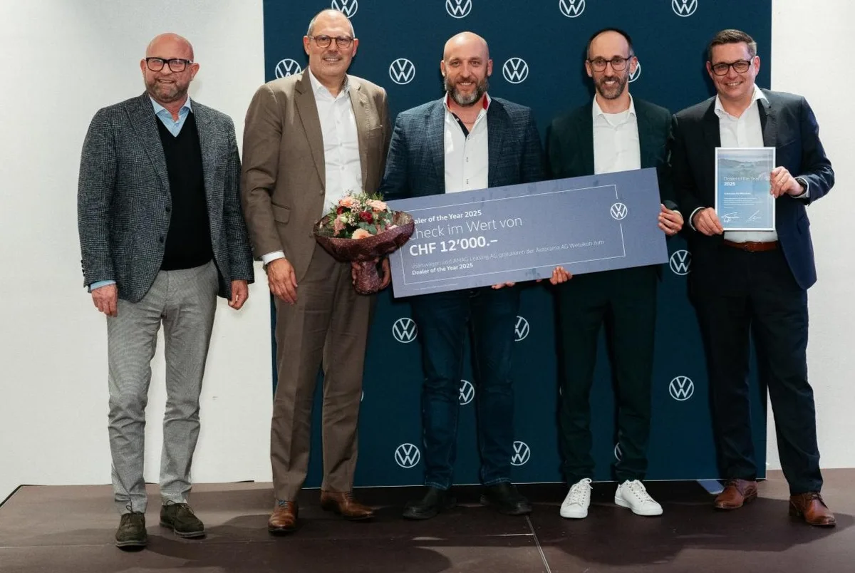 Fünf Männer in Anzügen halten einen grossen Check über 12'000 Franken.