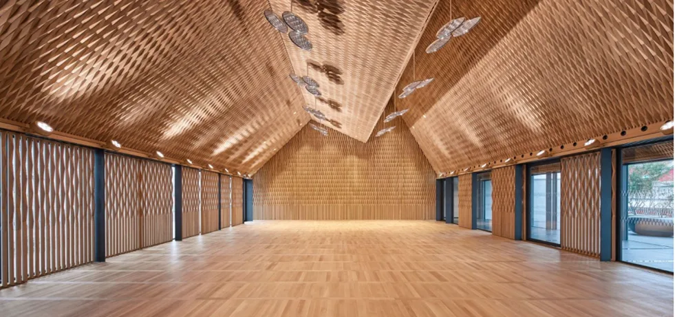 Blick in einen Saal, dessen Wand- und Deckenverkleidung aus 20'000 Eichenholzelementen besteht.
