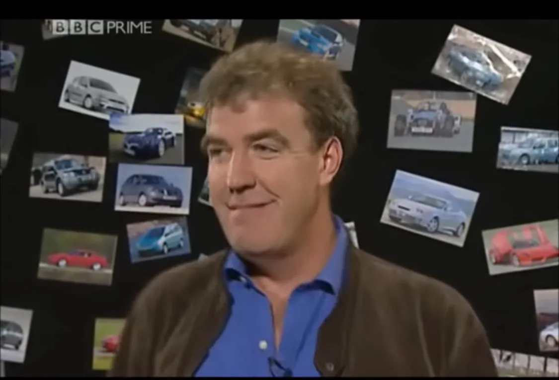 BBC-Moderator Jeremy Clarkson steht lächelnd vor einer Fotowand.