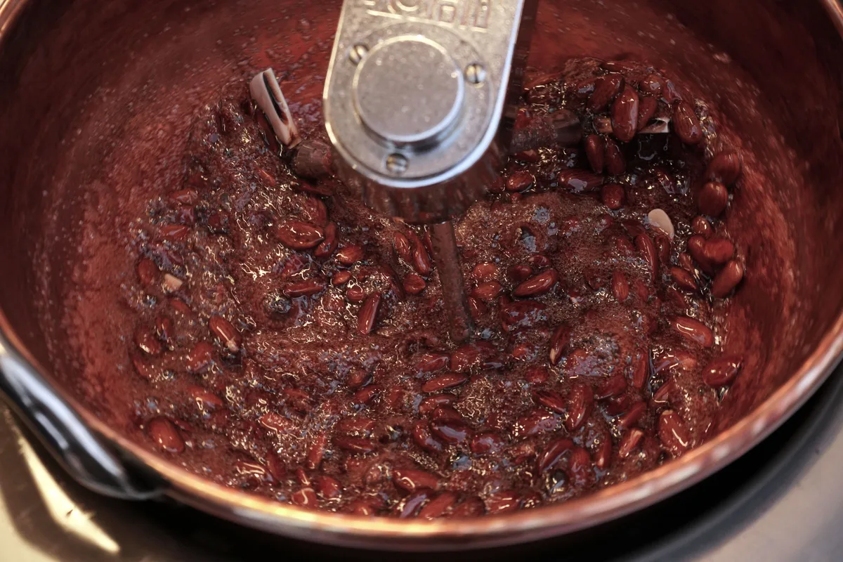 Blick in einen Topf, in dem gebrannte Mandeln produziert werden.