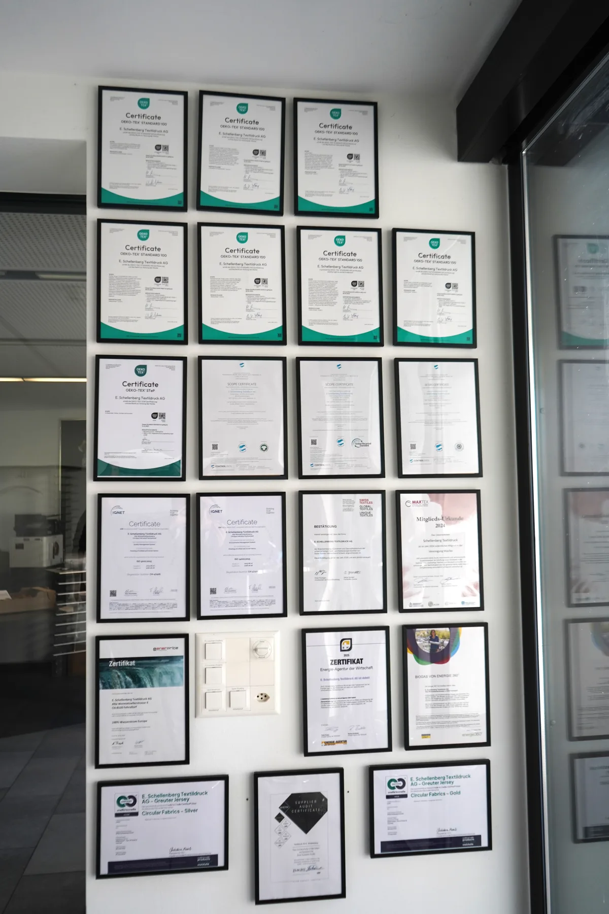 Eine Wand, an der mehr als 20 Diplome und Zertifikate hängen.