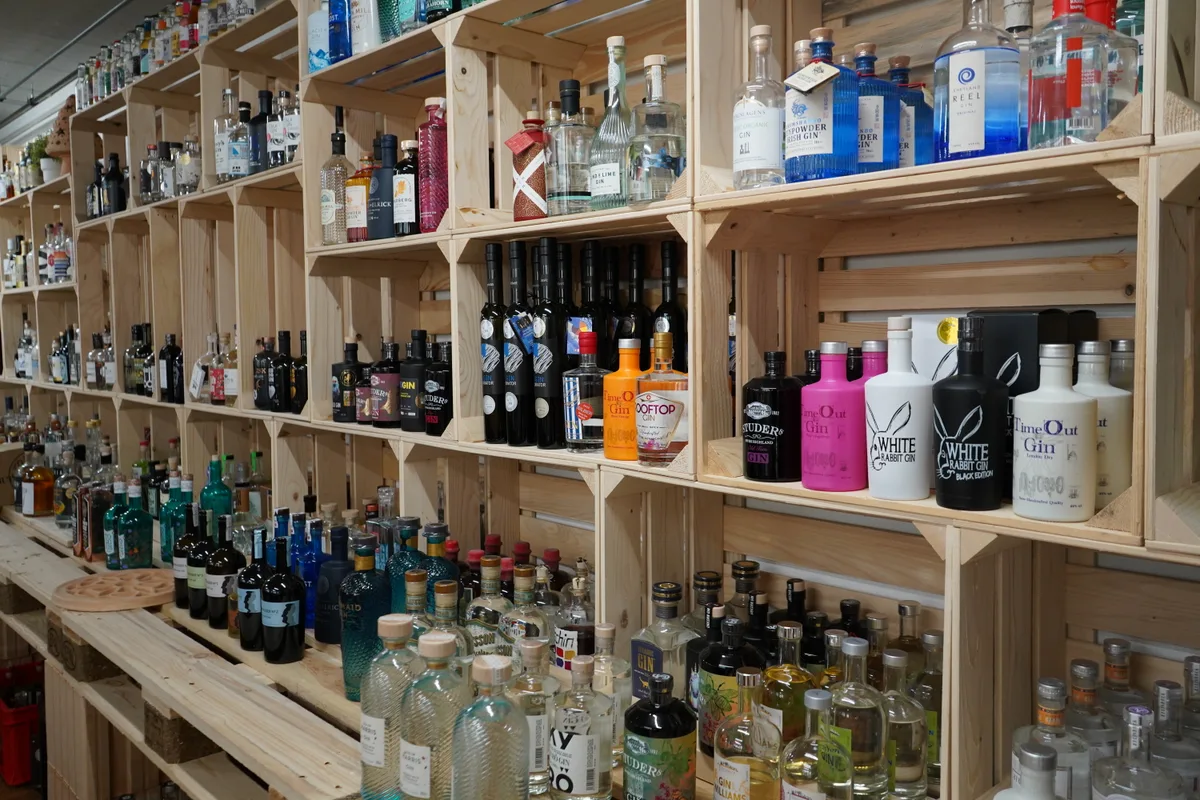 Einfache Holzregale voller Gin-Flaschen in der Gin-Garage in Wolfhausen.