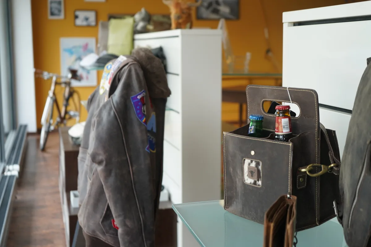 Das Schaufenster der Ryffel Felle + Leder AG. Man sieht eine Bikerjacke aus Leder und eine lederne Tasche, in der Bierflaschen stecken.