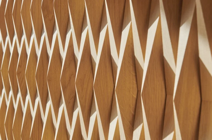 Eine Detailaufnahme des Innenausbaus des Saals im Drei-Häuser-Hotel Caspar in Muri. Man sieht pyramidenförmig geschnittene Eichenholzelemente.