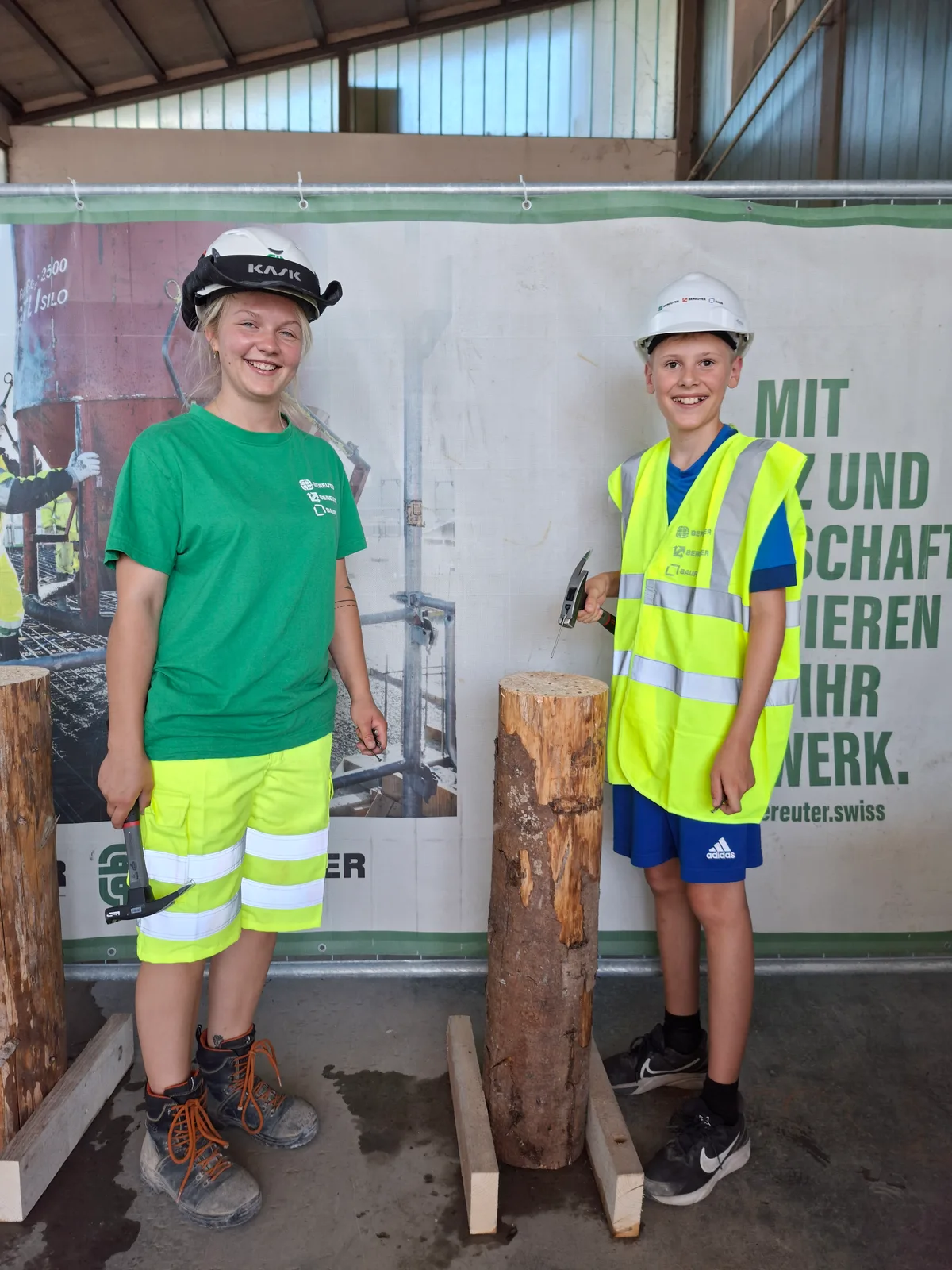Rund 20 Kinder nahmen am Ferienplausch teil – auch Mädchen waren dabei. Ein Mädchen und ein Junge stehen neben einem Holzpflock, in den man Nägel einschlagen kann. Beide halten einen Hammer in der Hand.