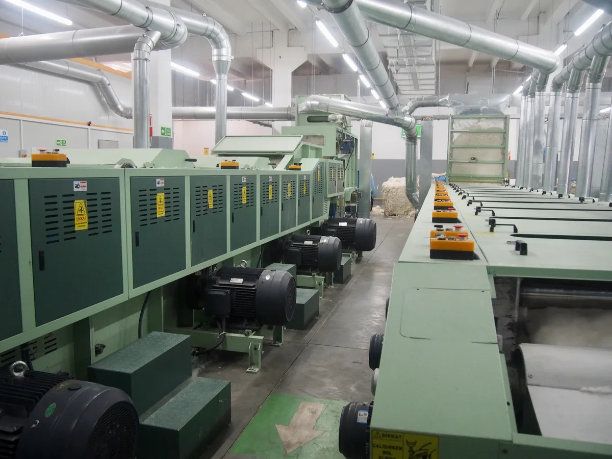 Produktion von Recycling-Baumwolle im Säntis-Werk in der Südtürkei. Man sieht Spindeln, auf die das Garn gewickelt wird.