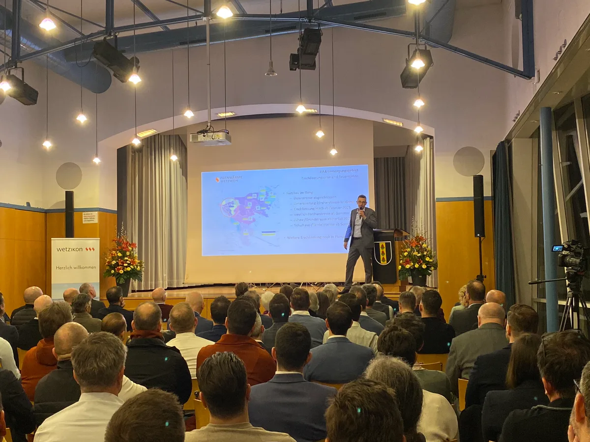 Menschen in einem Saal hören Daniel Weltin zu, VR-Präsident der Fernwärme Wetzikon AG.