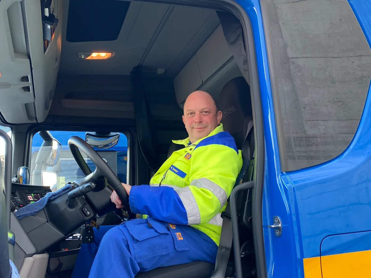 «Ich hatte mich auf einen harzigen Start eingestellt»: Dominik Tanner ist Werkstattchef bei der FBB AG. Dominik Tanner, in neongelber Arbeitskleidung, sitzt am Steuer eines Lkw.