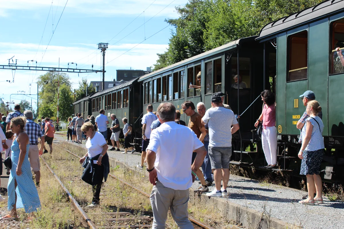 Menschen steigen aus alten Zugwaggons aus.