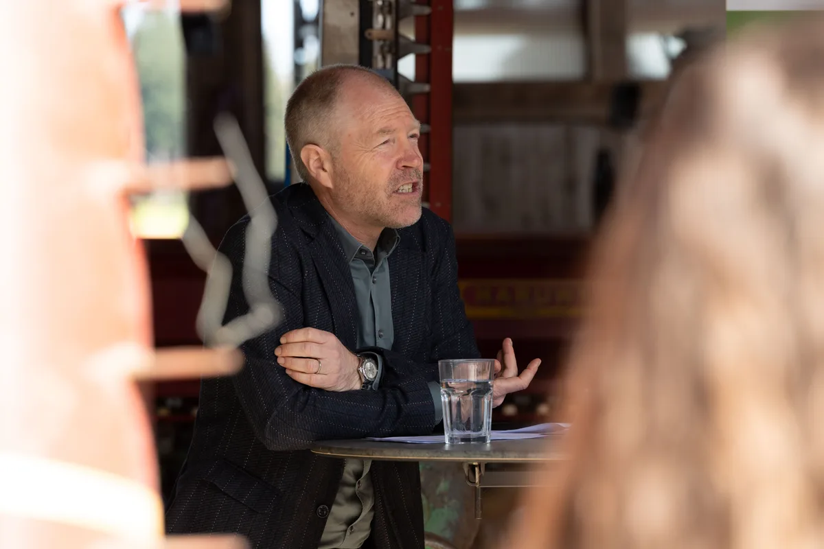 Anders Gautschi, Geschäftsführer der Stiftung Biovision. Ein Mann stützt sich auf einen Stehtisch und erklärt etwas.
