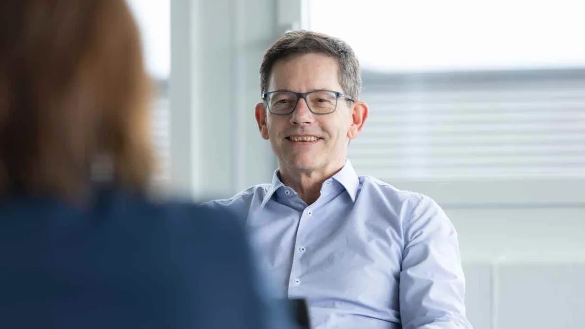 Ein Mann in hellblauem Hemd und mit Brille.
