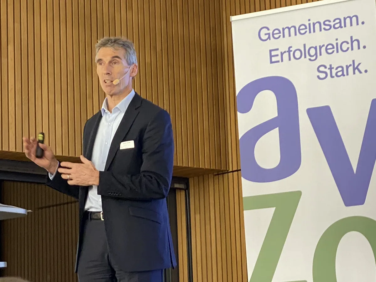 Ein Mann im Anzug referiert auf einer Bühne.